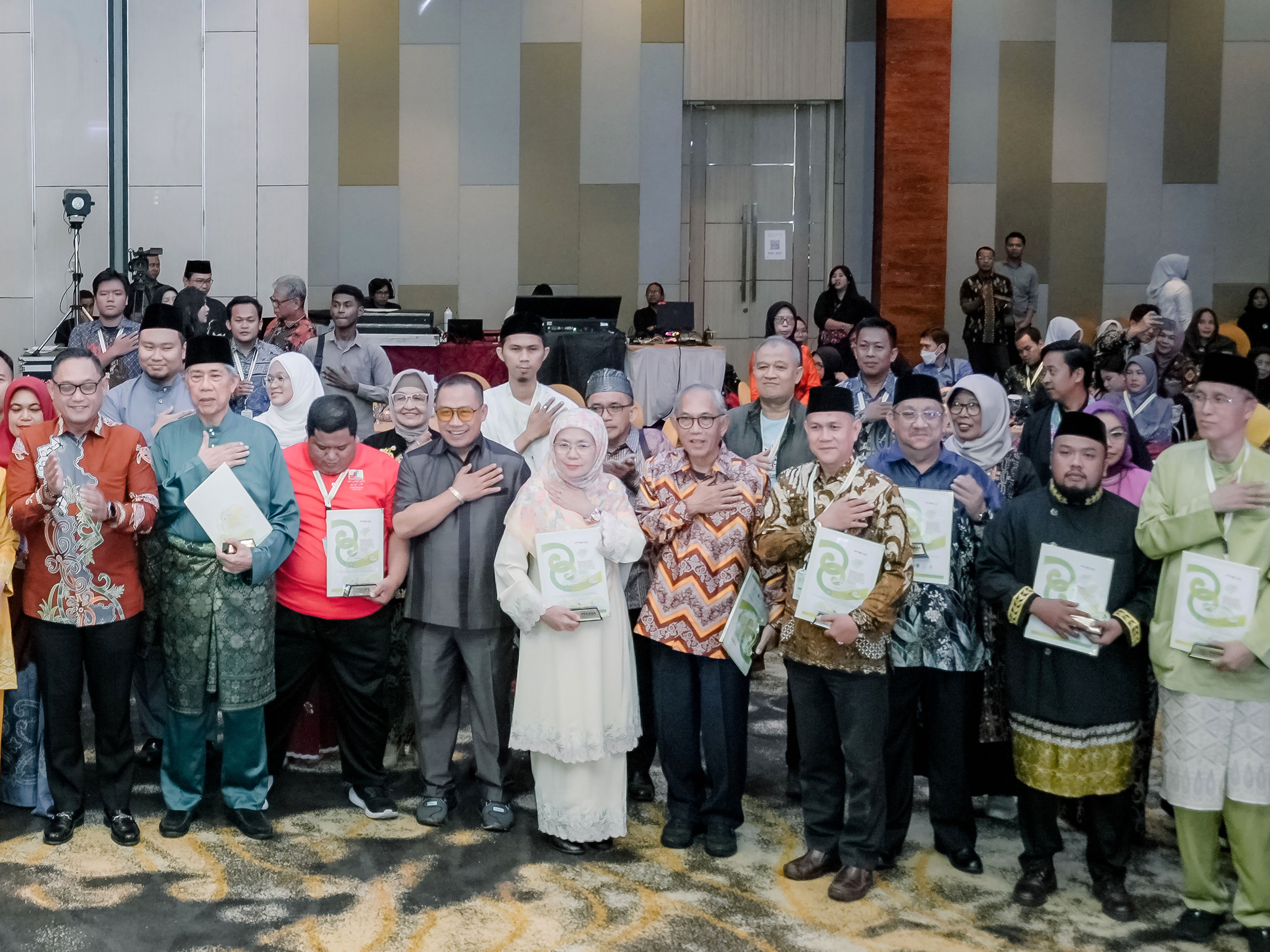Muhammad Sarip (bermasker) duduk di belakang saat foto seremonial pembukaan Dialog Serantau Borneo-Kalimantan (DSBK) XVI, 17 Juni 2025 (Foto: Dewan Kesenian Daerah Kalimantan Timur)